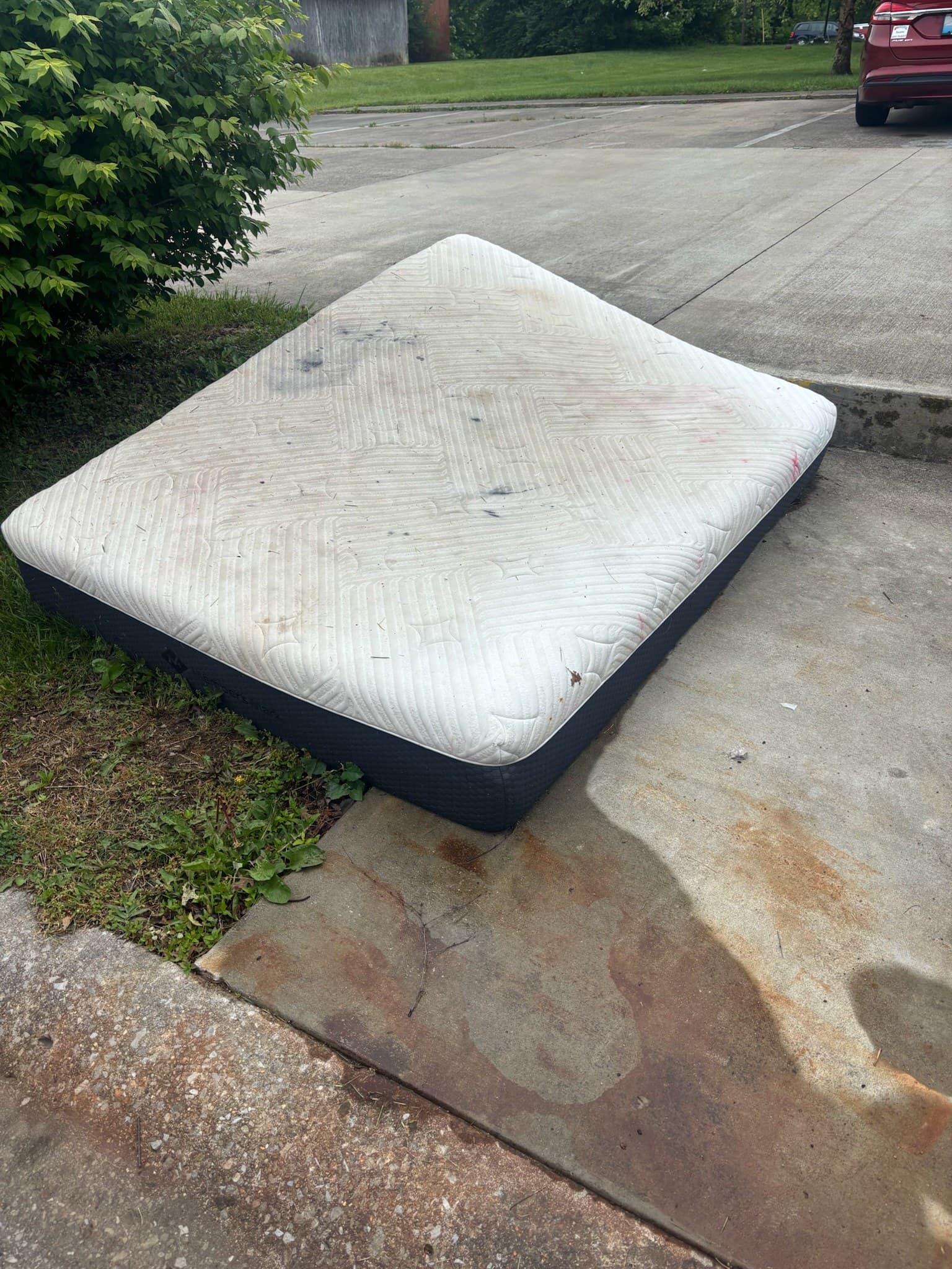 Mattress and bulk items at an apartment curb before pickup